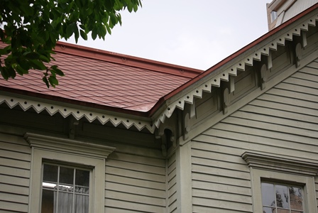 赤いカラー鉄板の屋根と白い下見板の壁